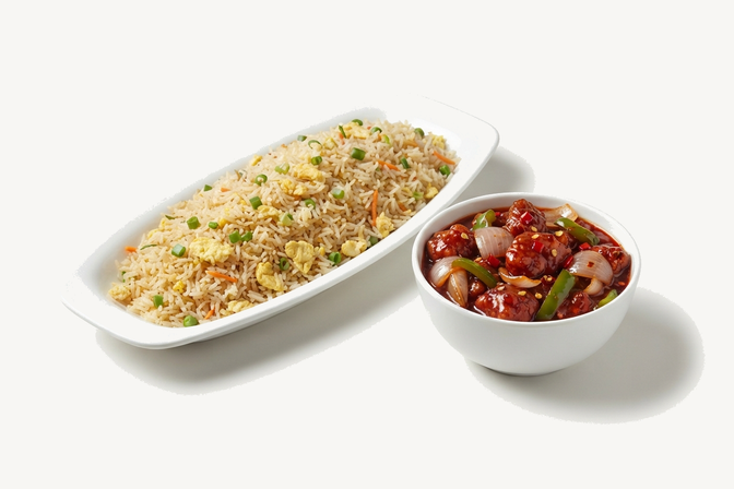 An oval dish of egg fried rice with peas and carrot, beside a bowl of chilli onion in a red sauce