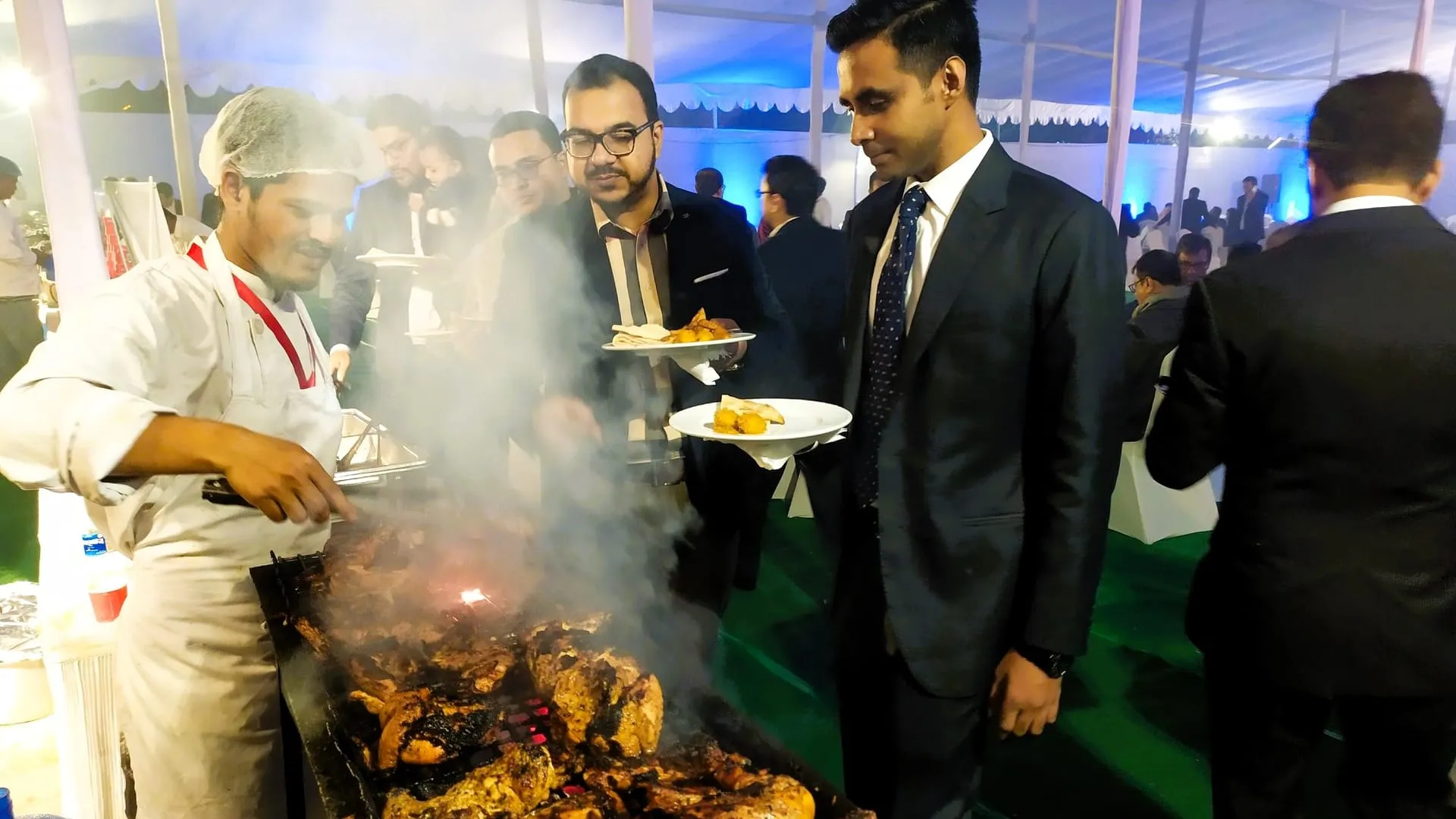 Serving staff at a buffet station with chafing dishes during an office event in Dhaka