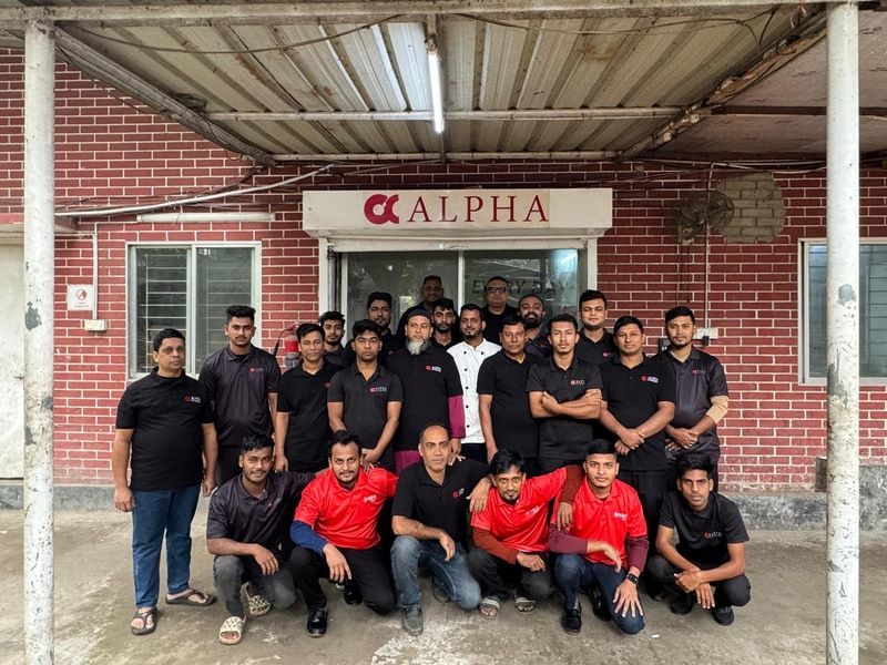 The Alpha Catering kitchen team in branded shirts outside the central kitchen entrance